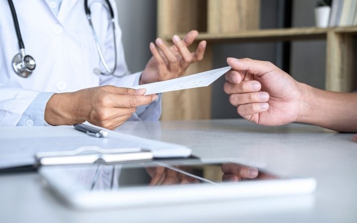 Medical marijuana doctor handing cbd prescription to patient
